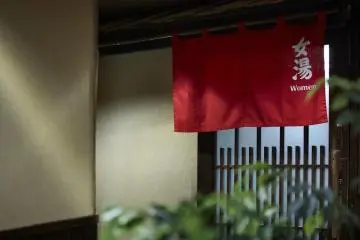 The bath for women is marked by red curtain (blue for men)