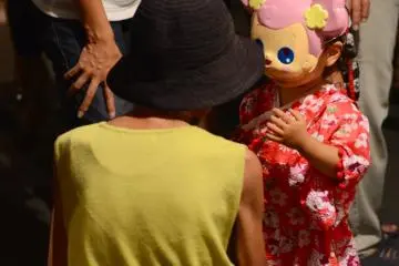Little girl trying out a Minnie Mouse mask