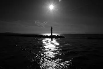 A black & white photo of a lighthouse from the ferry