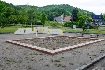 A large sandpit located in the center of the park