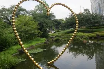 Kin no Kokoro, a sculpture by Jean-Michel Othoniel, reflects in the pond