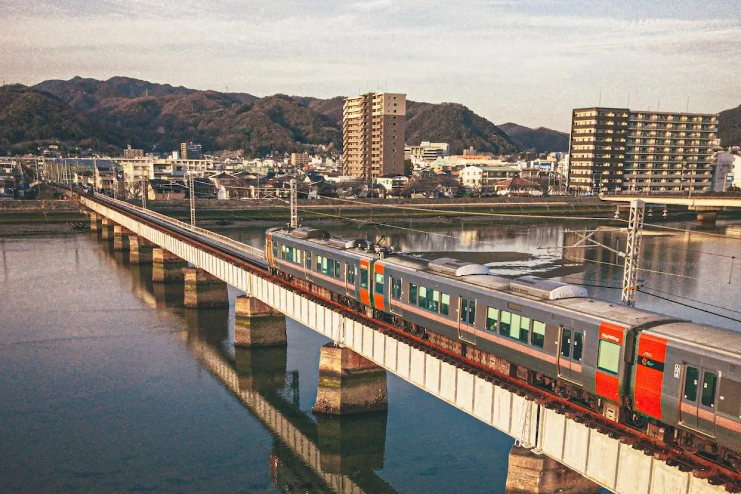 The JR Kabe Line travelling over the Ota River (Créditos de foto: eggbank / Unsplash)