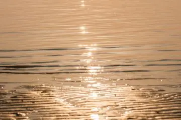 As the sun approaches the horizon the sea sparkles brightly into gold