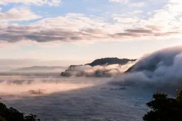 Diterangi oleh sinar matahari pagi, lautan awan mengalir ke laut seperti air terjun... Sungguh fantastis!