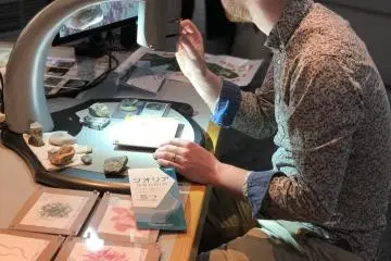 Hands on with a microscope, looking at the fine details of the volcanic rock.