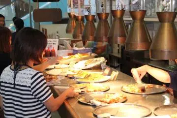 Hot lamps keep pizza warm along the buffet, but the pies don't remain too long as the line is busy and the staff is continuously adding new pizzas in to the mix