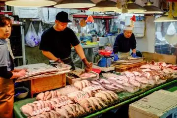 Les vendeurs préparent avec dextérité les fruits de mer frais pour les clients locaux