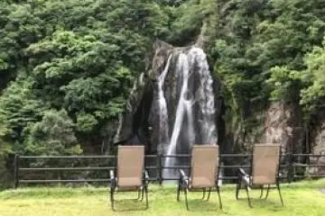 "Soaking" up the minus ions near a waterfall. Negative air ionization therapy in the forest. 