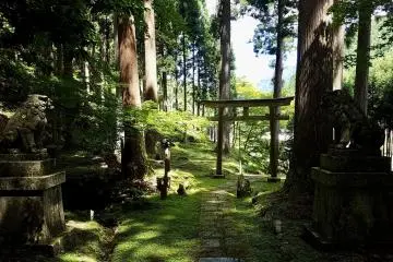 A torii with stone lions guarding secluded Tōfū-jinja shrine in the mountains north of Kyoto