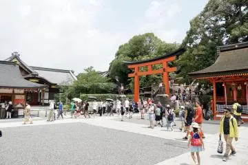Tourists pass a torii at Kyoto's Fushimi Inari Taisha