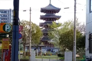 The pagoda of Kosho-ji Temple peeking through two modern buildings