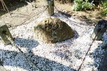 The large rock is surrounded by many small white stones