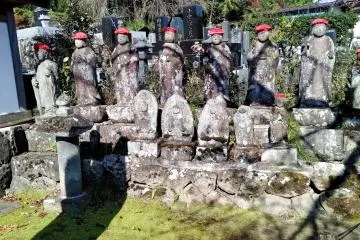 Jizo statues quietly stand at the roadside entrance