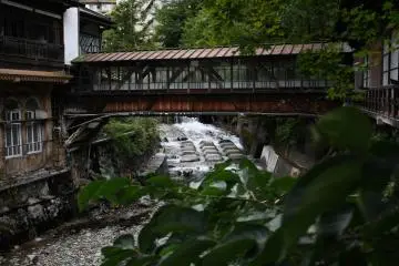 View the Arayu river rush under you from the red bridge