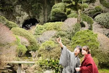 A couple in traditional costume points to the bamboo grove