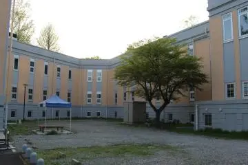 The interior side of the building facing the university looks completely different. To see the "face" of the building, circle around right and walk along the fence to the far corner under the trees.
