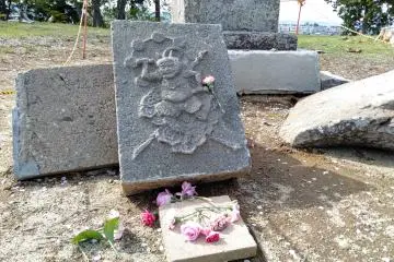 A broken stone lantern featuring the namesake deity "Rajin". 