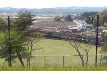 One edge of the park has a view of mountains, farmland, and a golf driving range.