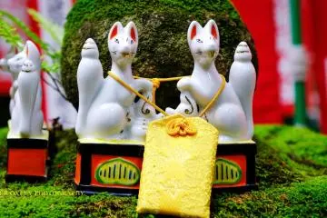 Miniature white porcelain foxes with an amulet