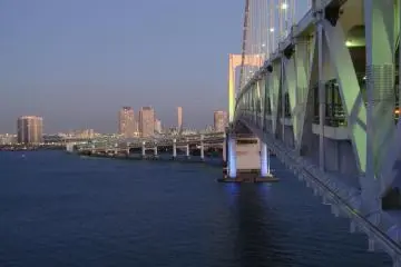 Rainbow Bridge menjelang matahari terbenam. Penerangan berbagai warna hanya dinyalakan ketika sudah gelap, atau selama perayaan khusus seperti Natal dan Tahun Baru.