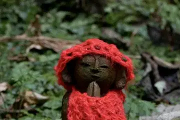 The smallest of the statues, seen clasping its hands