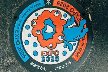 Expo 2025 Decorative Manhole Cover (Photo: <a href="https://unsplash.com/photos/a-close-up-of-a-sign-on-a-sidewalk-B8f6rZilCs4" target="_blank" rel="noreferrer noopener nofollow">Note Thanun</a> / Unsplash)