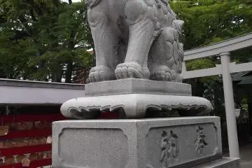 A lion stands sentinel by the shrine buildings