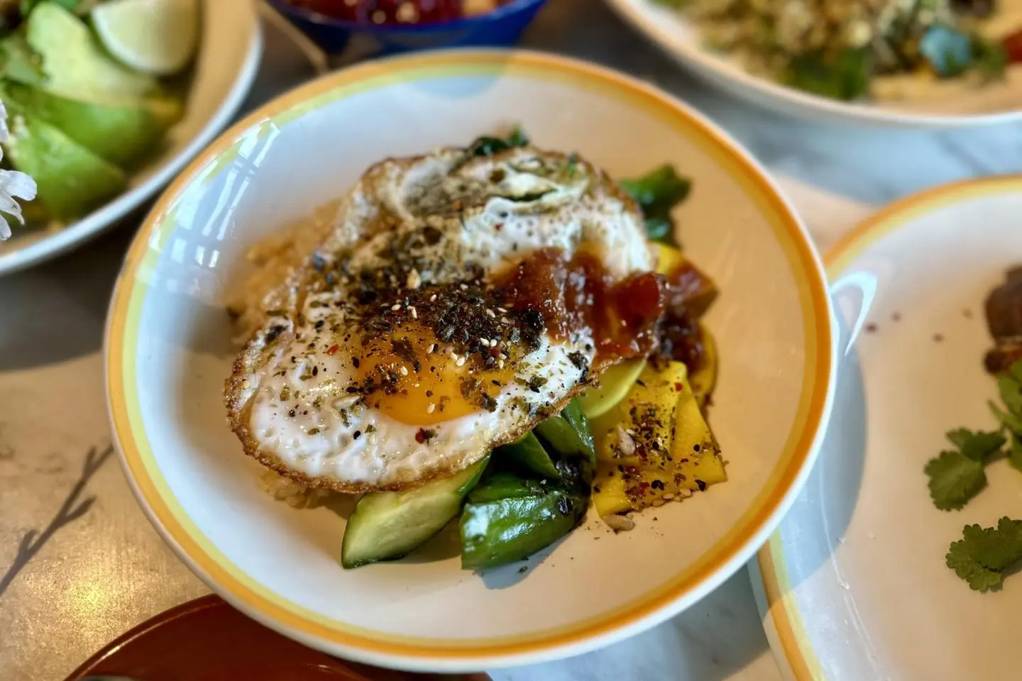 Seasoned rice and sesame greens topped with a crispy egg, furikake, and plum tamarind chutney