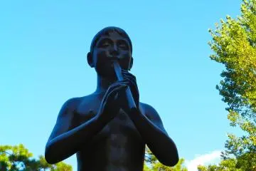 This statue of a young boy with his flute stands on the edge of the park, near the library.