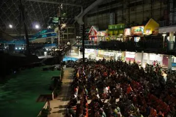 밤에 워터파크 안에서 관객들은 훌라 쇼를 즐긴다