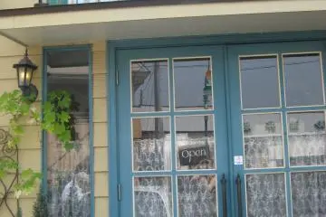 A La Bonne Maman is in a yellow building, with parking for several cars in the front