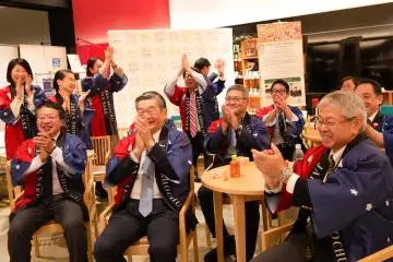 Stakeholders celebrate at the Japanese Sake Information Center in Toranomon, Tokyo, during the live broadcast of the UNESCO decision