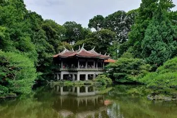 Shinjuku Gyoen has plenty of scenic spots making it worthy of a visit (Photo: <a href="https://unsplash.com/photos/a-pond-surrounded-by-trees-with-a-building-in-the-background-t_63fw-dg_Q" target="_blank" rel="noreferrer noopener nofollow">Kalyan Mukherjee</a> / Unsplash)