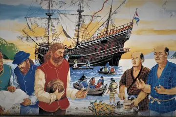 The arrival of the ship Liefde at the coast of Kyushu. William Adams wears a blue hat and clothes, and Jan Joosten red clothes. It was their first encounter with the Japanese in 1600. (Photo: <a href=" https://www.wikitree.com/photo/jpg/Van_Lodensteyn-8" target="_blank" rel="noreferrer noopener nofollow">N. Tamada (CC-0)</a>)