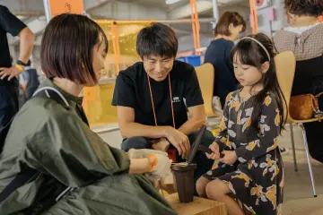A young girl experiencing crafts at Craft Fair Tsuginote