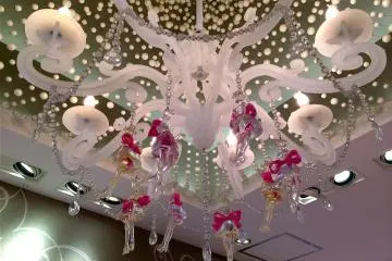 De magnifiques décorations telles que ce chandelier rose accentuent l'atmosphère rappelant une maison de poupée