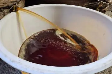 Fresh soy sauce draining from a vat