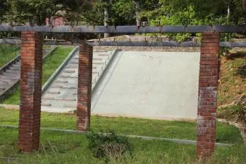 <p>This concrete slide is trimmed by well-maintained grass but nevertheless surrounded by old and neglected structures</p>