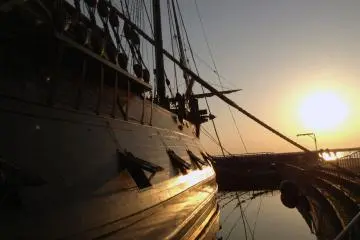 <p>Los ca&ntilde;ones del barco descansan tranquilamente en sus escotillas al atardecer.</p>