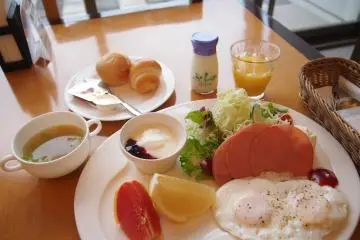 <p>เมนูมื้อเช้าแบบตะวันตก: ขนมปังรสเลิศ แฮม ไข่ โยเกิร์ต ผลไม้และซุปกระหล่ำปลี</p>