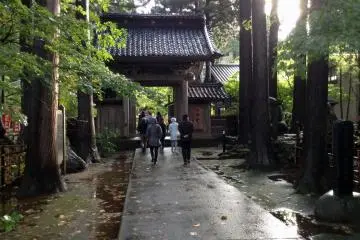 <p>The front main gate is flanked by towering trees at&nbsp;Gyokusenji Temple in the town of Tsuruoka, Yamagata Prefecture</p>