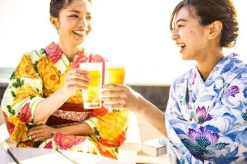 Why not enjoy summer in one of the beer gardens near Namba (Photo: <a href="https://stock.adobe.com/cy_en/images/%E6%B5%B4%E8%A1%A3%E3%81%AE%E5%A5%B3%E6%80%A7%E3%81%9F%E3%81%A1%E3%81%AF%E6%B5%B7%E8%BE%BA%E3%81%A7%E4%B9%BE%E6%9D%AF%E3%81%97%E3%81%A6%E3%81%84%E3%82%8B/203190205" target="_blank" rel="noreferrer noopener nofollow">Monet</a> / stock.adobe.com)