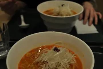 <p>White ramen includes sesame, thick green onions, and bean sprouts in a spicy broth</p>