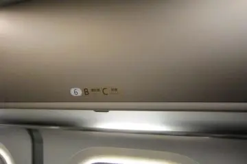 Overhead rack has cover like the ones in an airplane