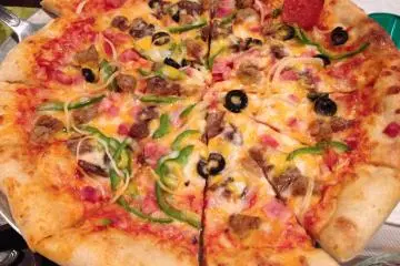 <p>The Surfside Special Pizza is made in Okuma's outdoor pizza oven and comes with&nbsp;pepperoni, ham, bacon, sausage, peppers, onions, mushrooms and black olives smothered with cheese</p>