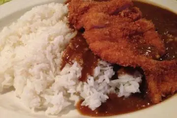 <p>The Surfside's Special Blend Curry sauce on a large chicken cutlet with steamed rice</p>