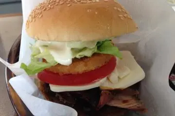 The A&amp;W burger consists of an all beef patty, roast beef, and "real" American cheese sliced thick from a block - not taken from a single serving wrap - as well as lettuce, tomato, onion ring, and mayonnaise on a sesame seed bun&nbsp;