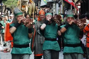 The dragon warriors play a traditional horn in a procession through the streets like the pied piper with the Seiryu-e behind them.
