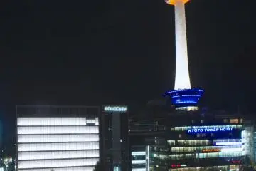<p>Kyoto Tower as seen from JR Kyoto Station.&nbsp;The first four floors of the building house several commercial areas, including a souvenir shop. The neighborhood has undergone a bit of transformation recently, with Yodobashi Camera which has opened just in the adjoining premises.</p>