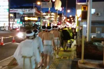<p>A traditional festival in progress is juxtaposed against a busy city street.&nbsp;</p>